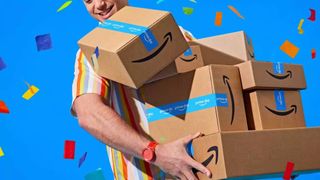 Amazon Prime Day deals Man holding seven Prime Day boxes against blue confetti background